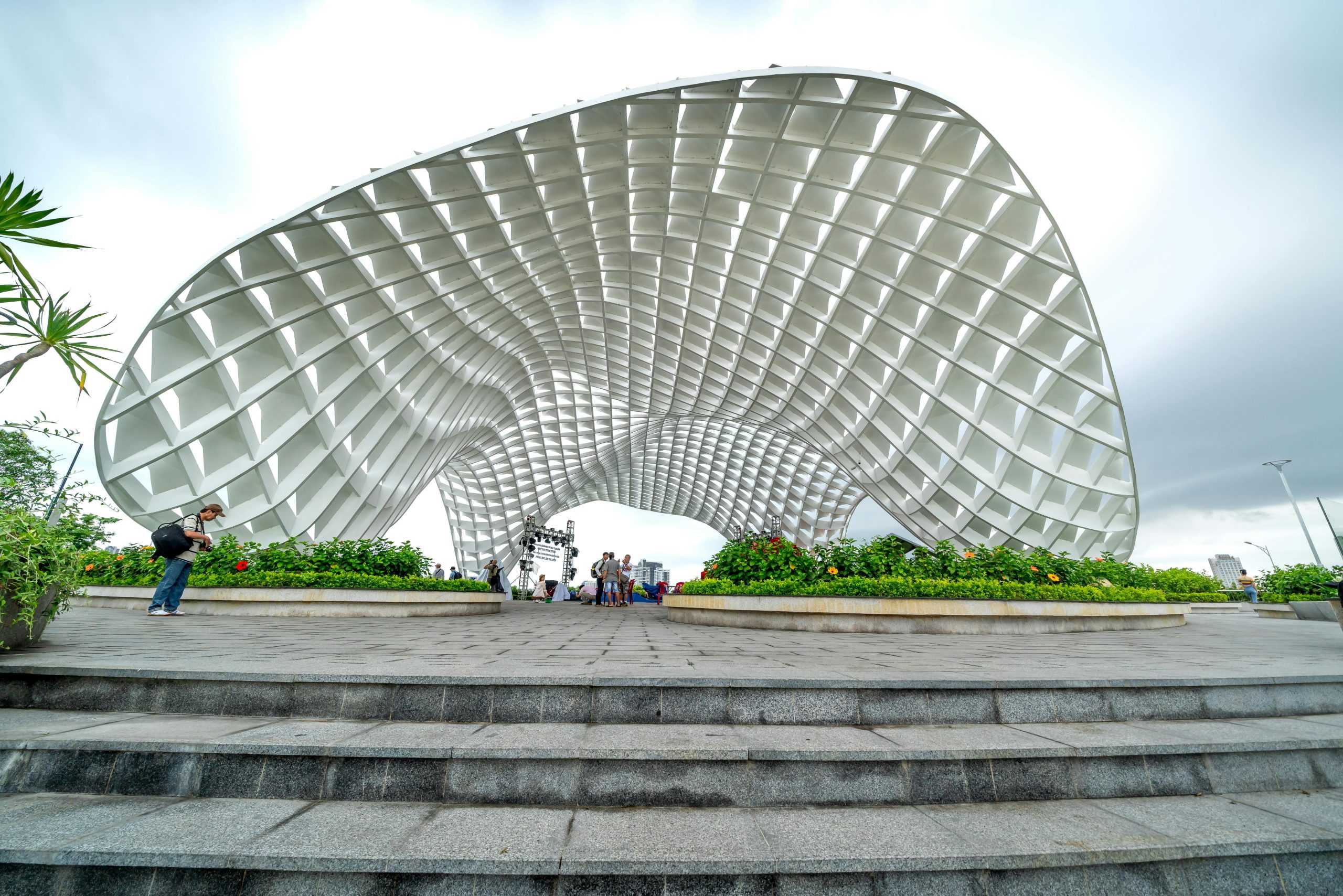 Photo of the iconic Apec Park landmark in Da Nang, Vietnam, featuring tourists and a cloudy sky.